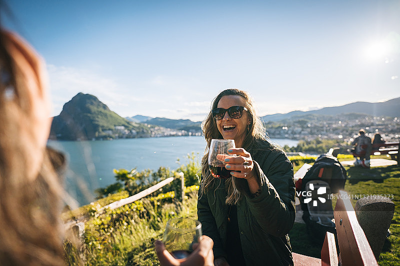 年轻女人在湖边景点品酒图片素材