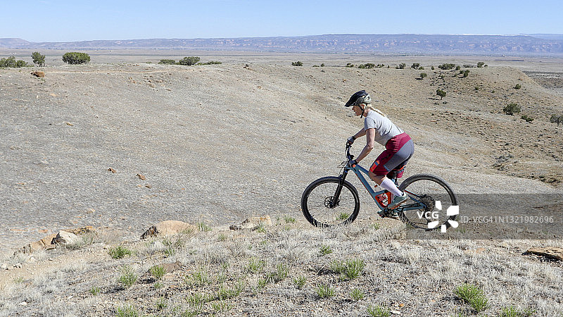女山地自行车手在沙漠中骑行图片素材