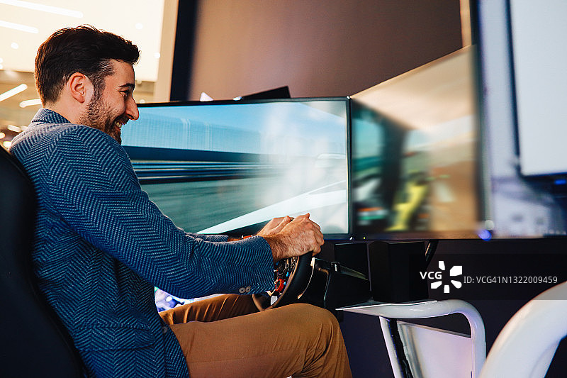 男人在街机上玩赛车游戏图片素材