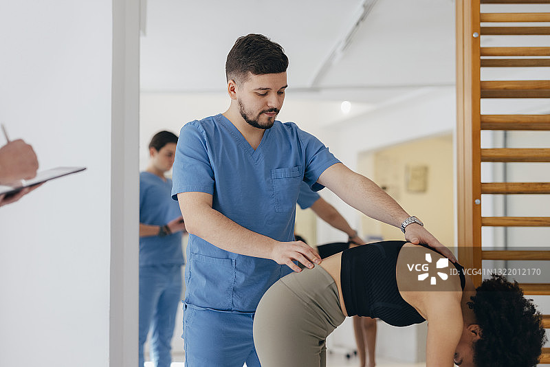 理疗师检查病人背部图片素材
