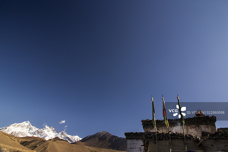位于尼泊尔木斯塘地区，卡利甘达基河沿岸的卡格贝尼村庄，在石堆建筑顶部的藏族祈祷旗图片素材