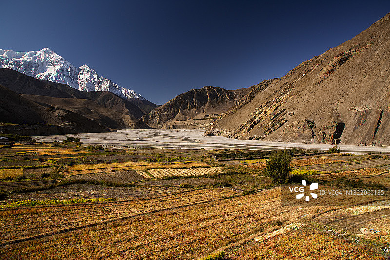 尼泊尔木斯塘地区：卡格贝尼村的西向鸟瞰，卡利甘达基河沿岸的农作物和尼尔吉里北峰图片素材