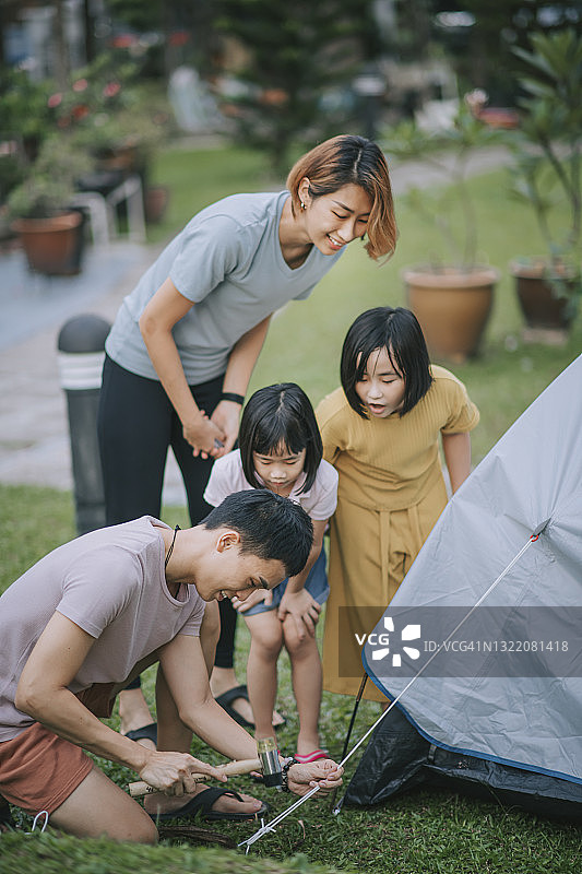 中国亚洲父亲在后院搭建露营帐篷图片素材