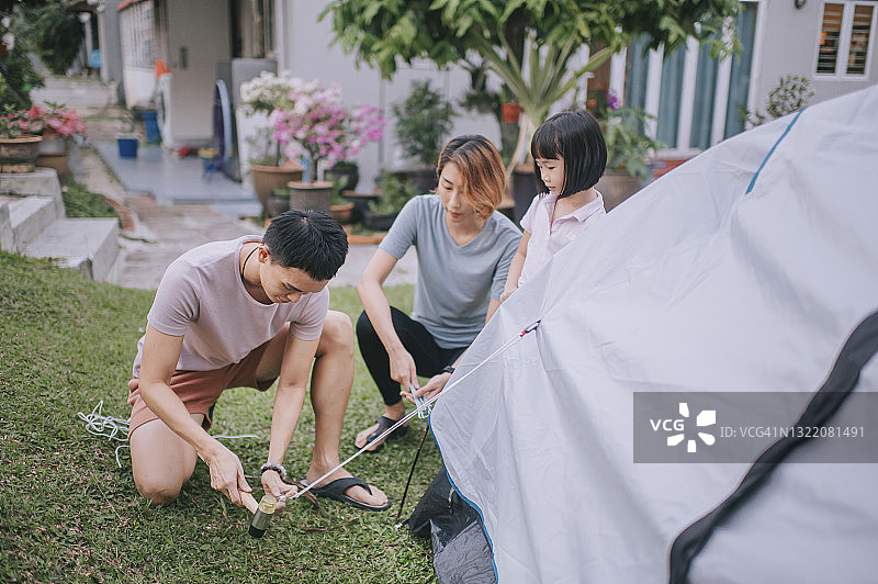 中国亚洲父亲在后院搭建露营帐篷图片素材