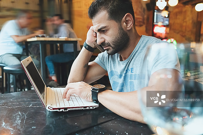 男子在咖啡馆使用笔记本电脑图片素材