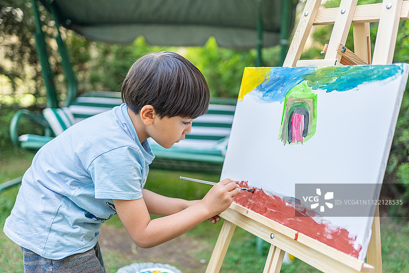 在花园里绘画的小男孩图片素材