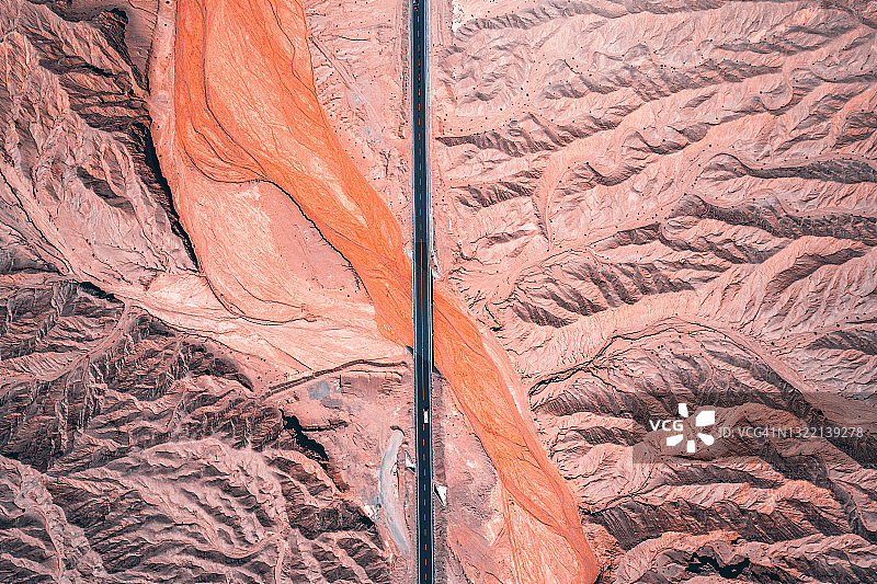 青海红色干涸河道上方的道路鸟瞰图图片素材