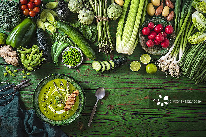 绿色木桌上的纯素生蔬菜配绿芦笋汤或豌豆汤图片素材