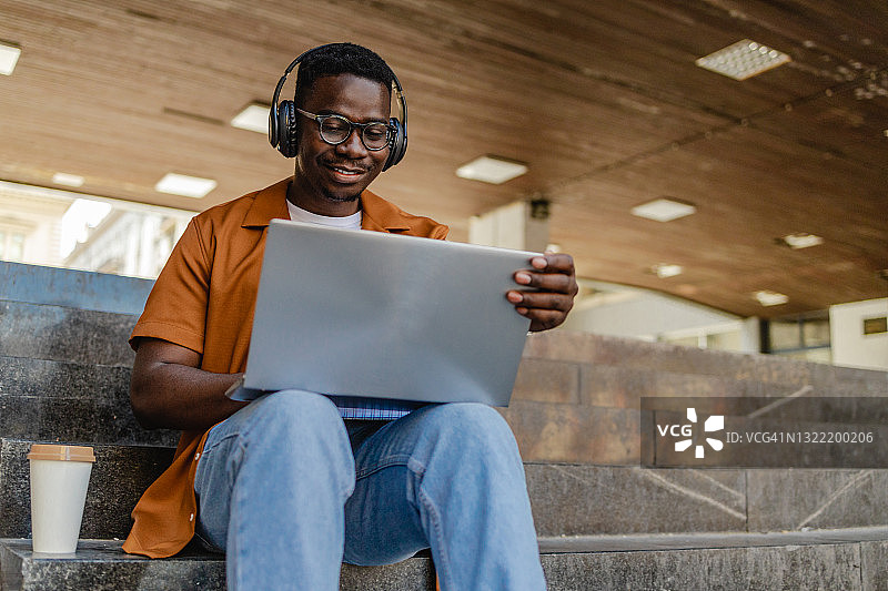 年轻男人在户外使用笔记本电脑图片素材