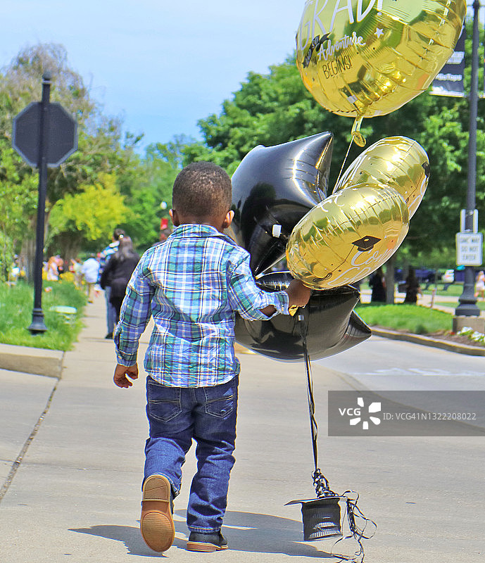男孩手拿毕业气球图片素材