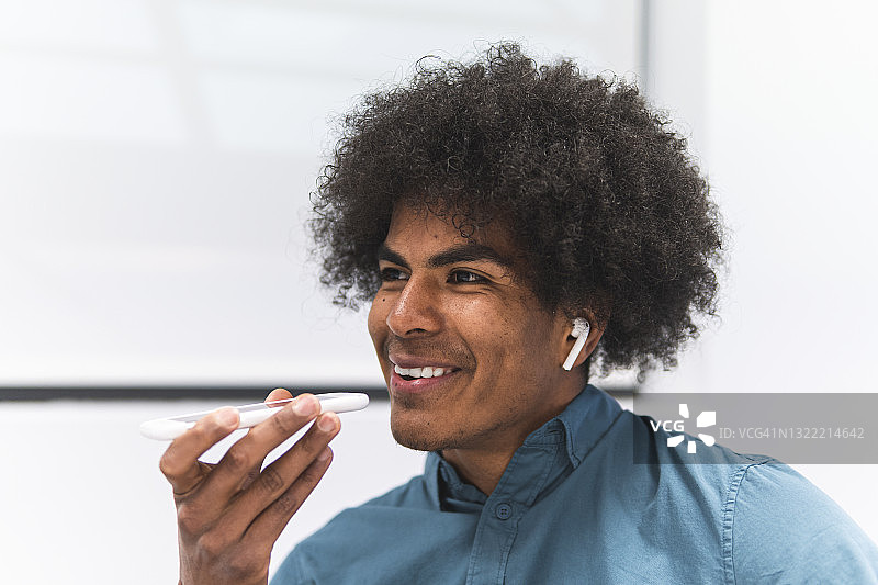 在办公室通过智能手机发送语音消息的商人图片素材