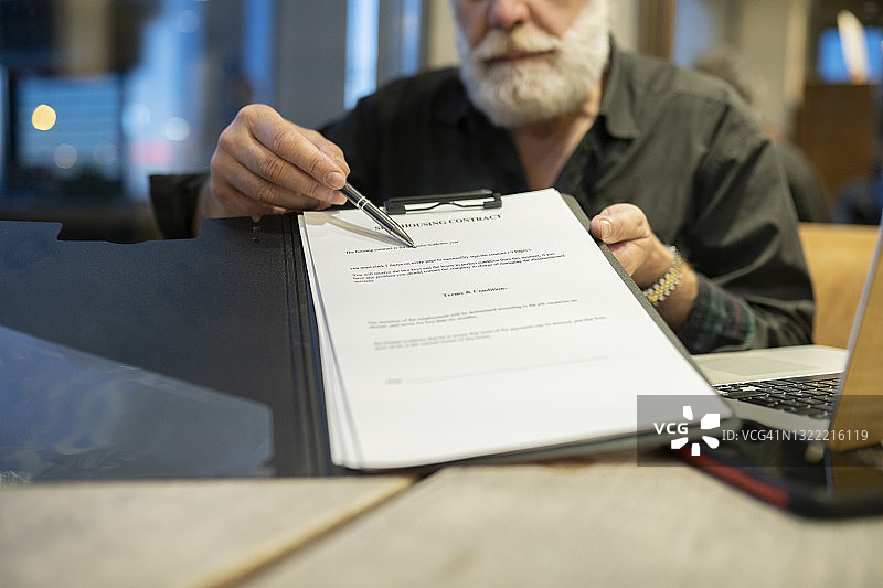 男保险代理人在办公室指着合同图片素材