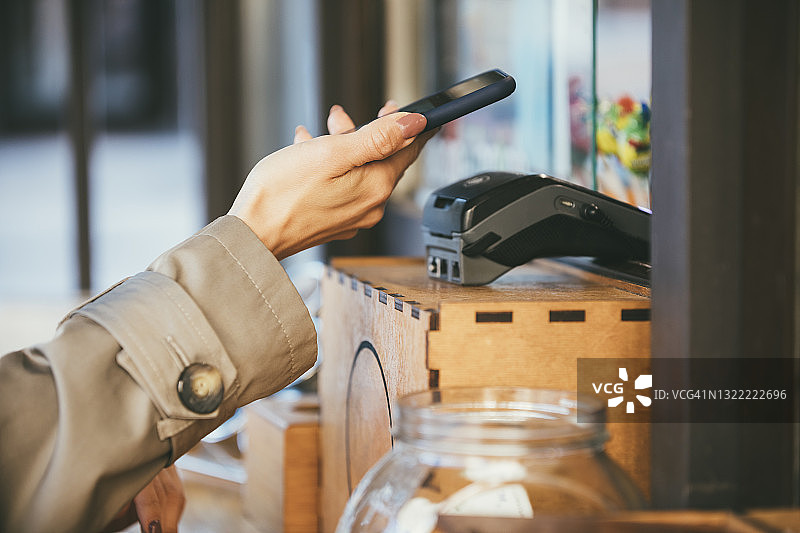 中年女人在结账时使用手机付款图片素材