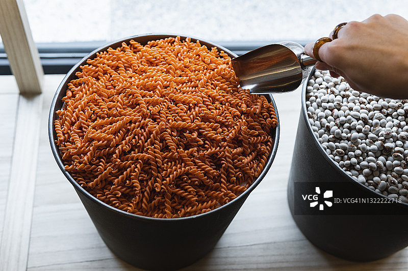 在超市用勺子购买意大利面的女人图片素材