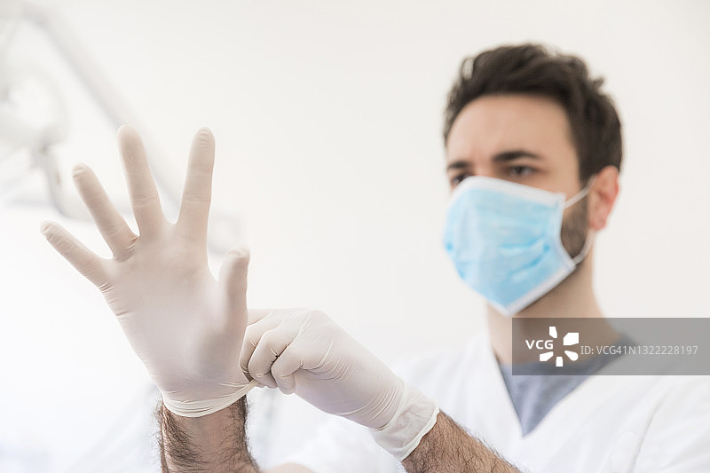男牙医在诊所戴防护手套图片素材