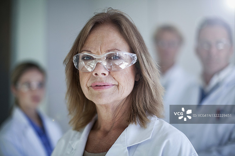 戴防护眼镜的女医生与同事在医院图片素材