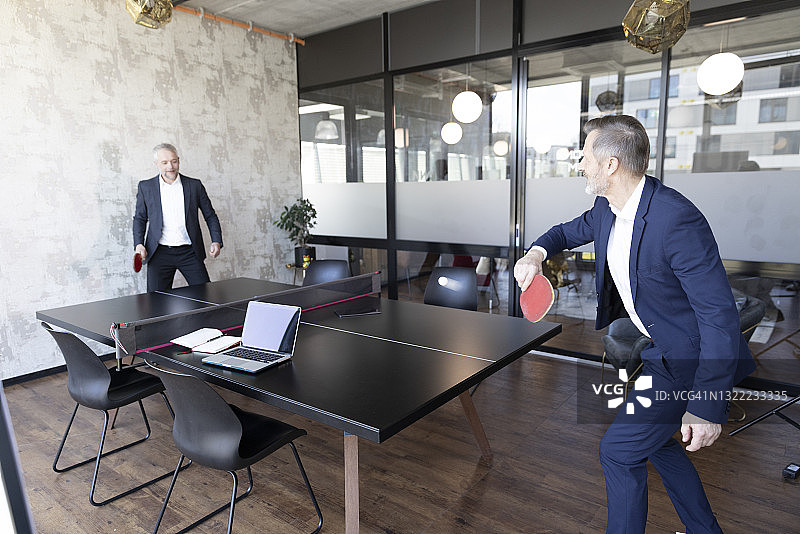 在办公室打乒乓球的商人图片素材