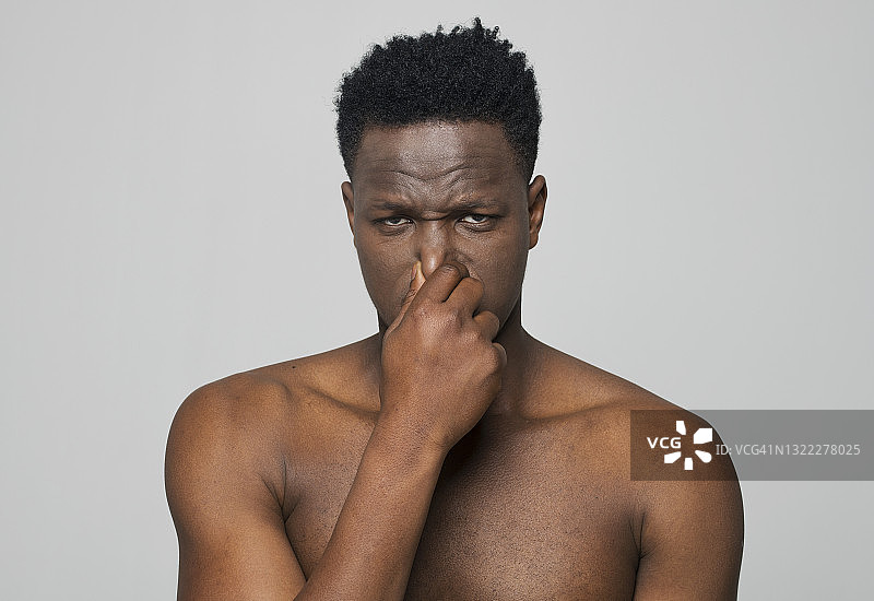 年轻男子捏鼻子的特写图片素材