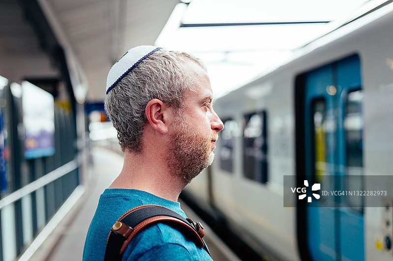 戴着小圆帽的犹太男人在城市里等火车图片素材