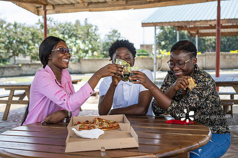 朋友们在披萨上祝酒图片素材