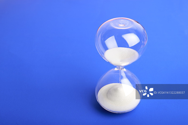 蓝色背景上的沙漏，风景图片素材