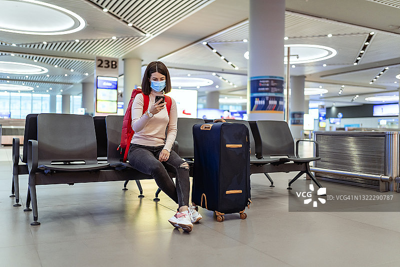 在机场航站楼大厅使用智能手机的乘客图片素材