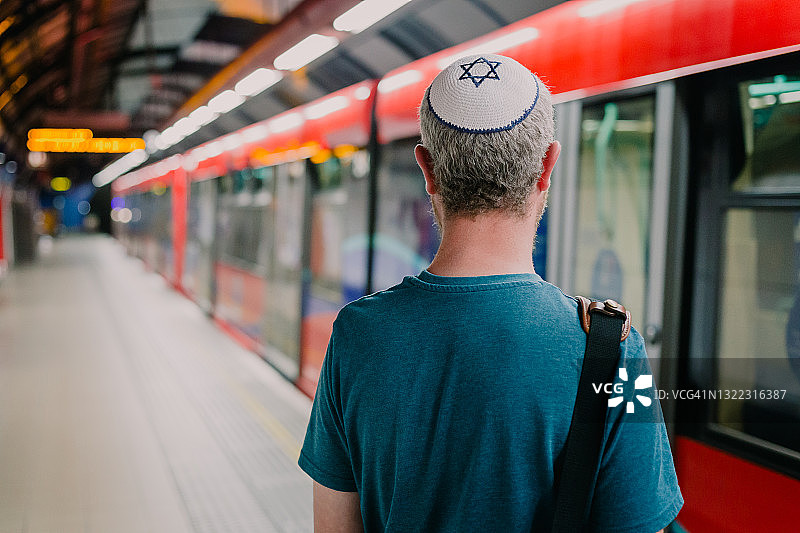 戴着小圆帽在城市里等地铁的犹太男人图片素材