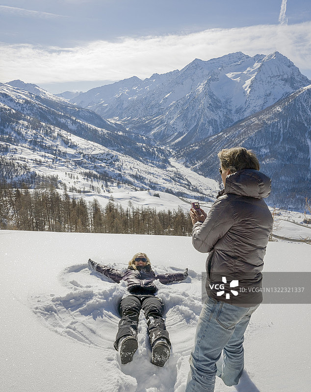 男人拍摄女人制作雪天使图片素材