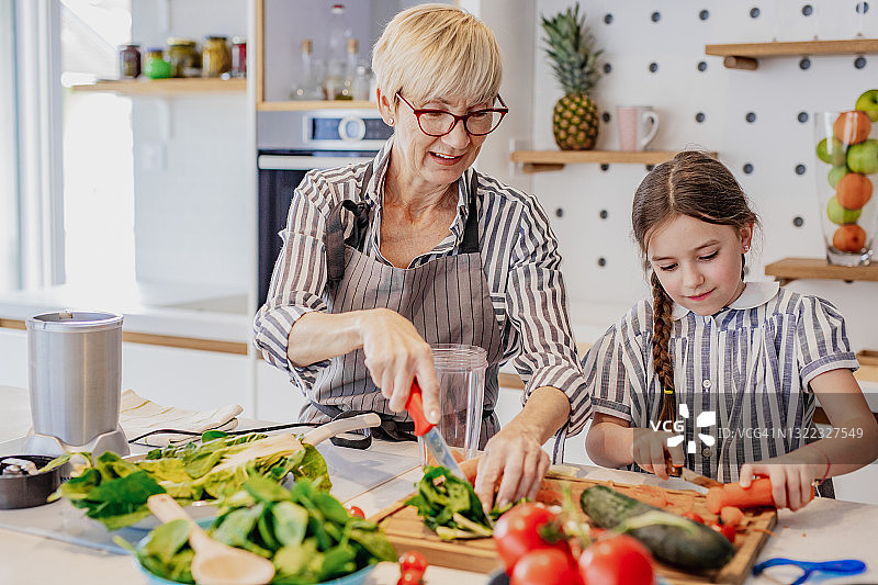 祖母和孙女在厨房里做健康的饭菜图片素材