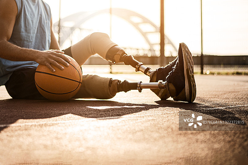 在篮球场休息的假肢男人图片素材