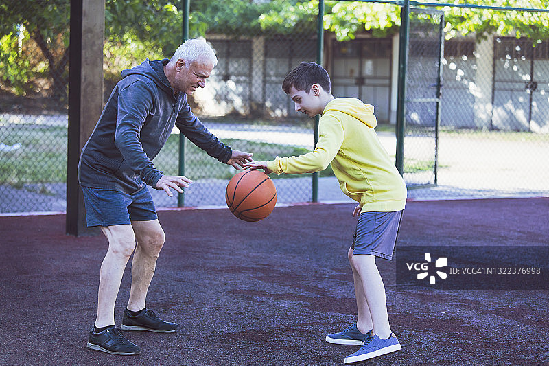 快乐的祖孙练习篮球图片素材