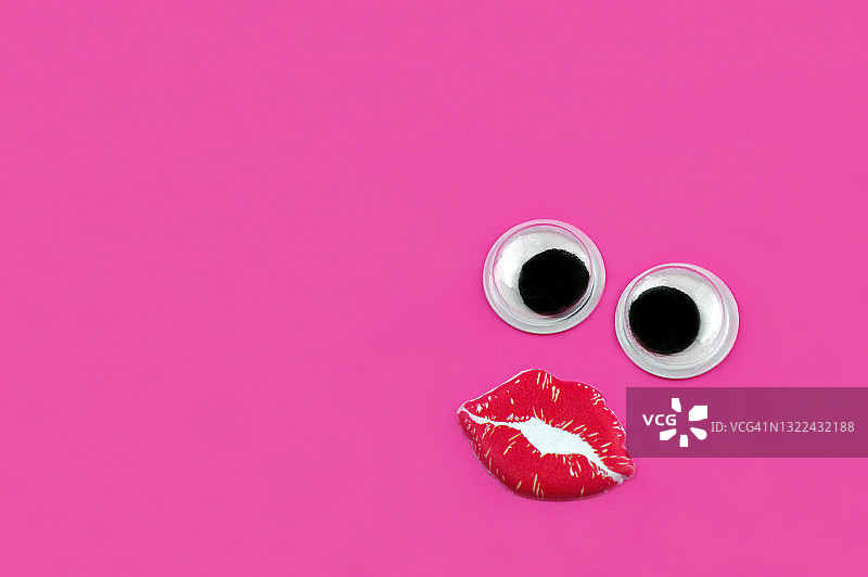 粉色背景上的拟人化趣味女性亲吻表情图片素材