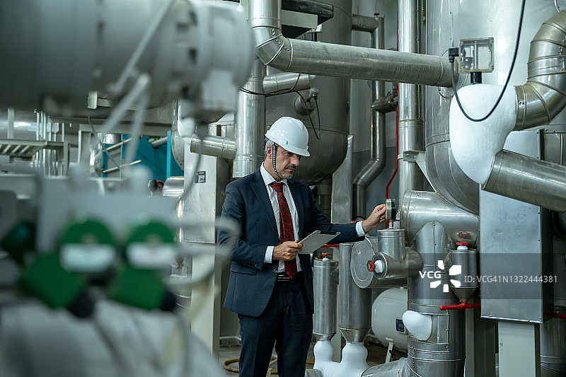 工厂工程师检查锅炉房中的高压水管图片素材
