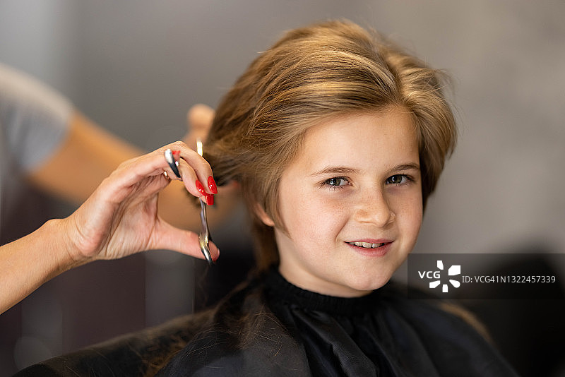 快乐的男孩在理发店理发图片素材