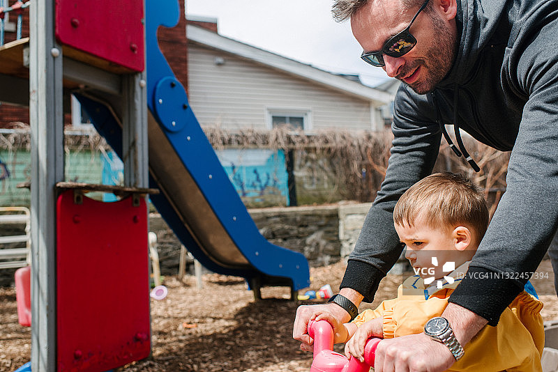 加拿大家庭场景：父亲与儿子在游乐场骑自行车图片素材