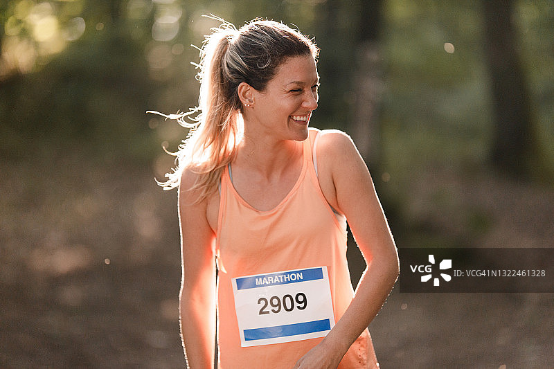 快乐的女马拉松运动员在自然中跑步图片素材