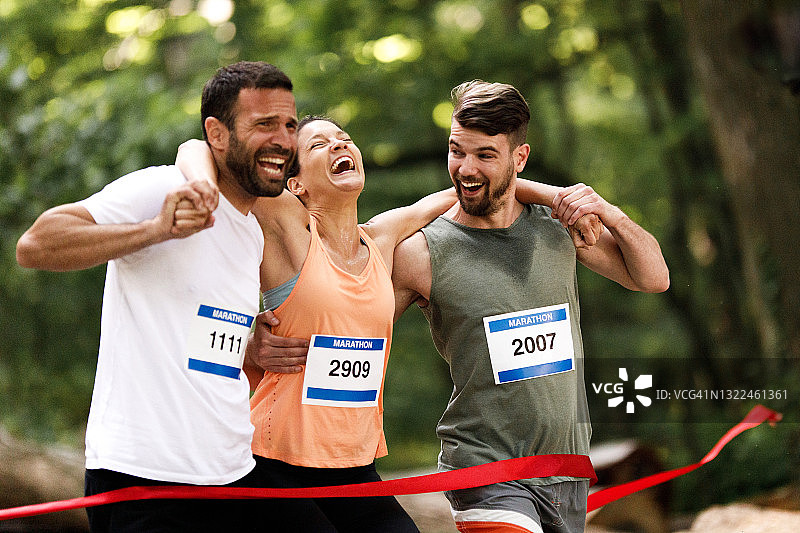 马拉松比赛中，男人们抬着疲惫的运动员，背景是日落图片素材