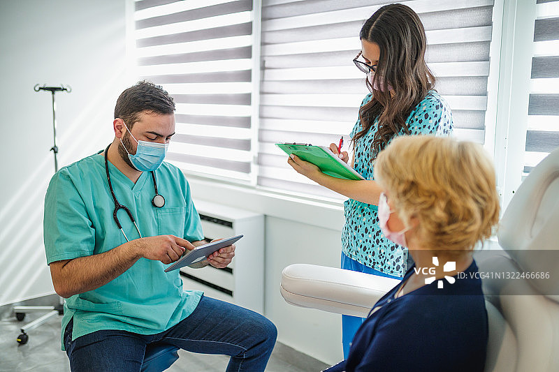 医生用平板电脑检查病人病历，护士做笔记图片素材