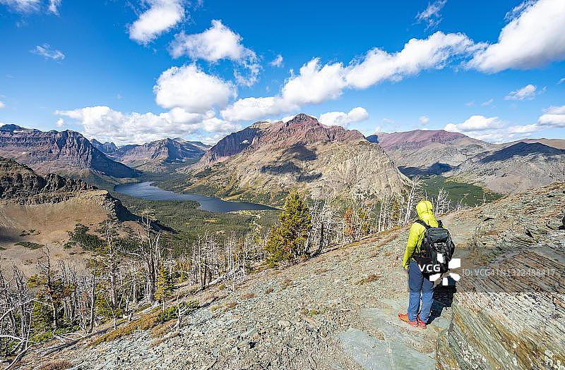 徒步者在通往风景点的路上，眺望双药湖、 rising wolf山和Sinopah山，美国蒙大拿州冰川国家公园图片素材