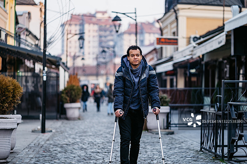 使用手杖在市中心受伤行走的男人图片素材