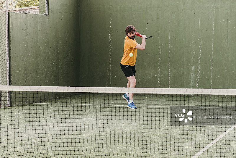 桨式网球运动员的反手击球图片素材