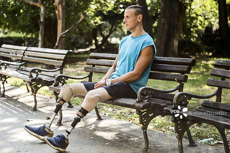 坐在公园长椅上的残疾男子图片素材
