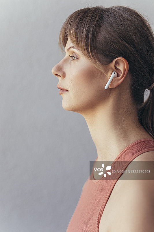 戴着无线耳机的美丽健身女性肖像图片素材