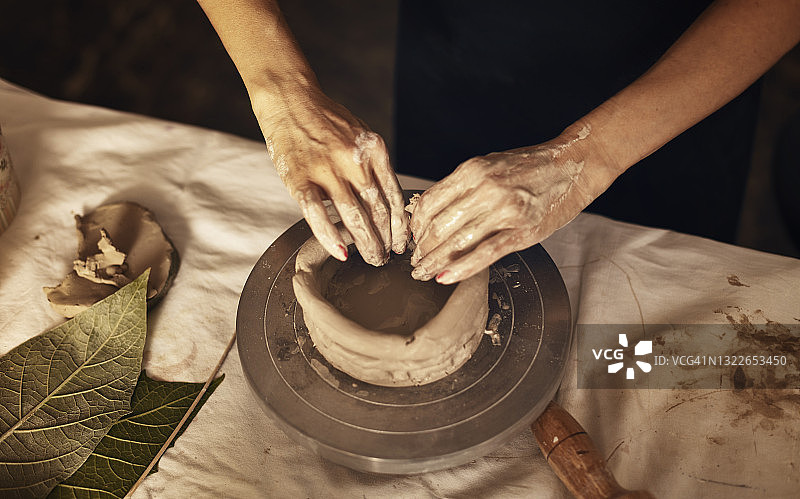 女陶瓷艺术家雕刻粘土和制作碗特写图片素材