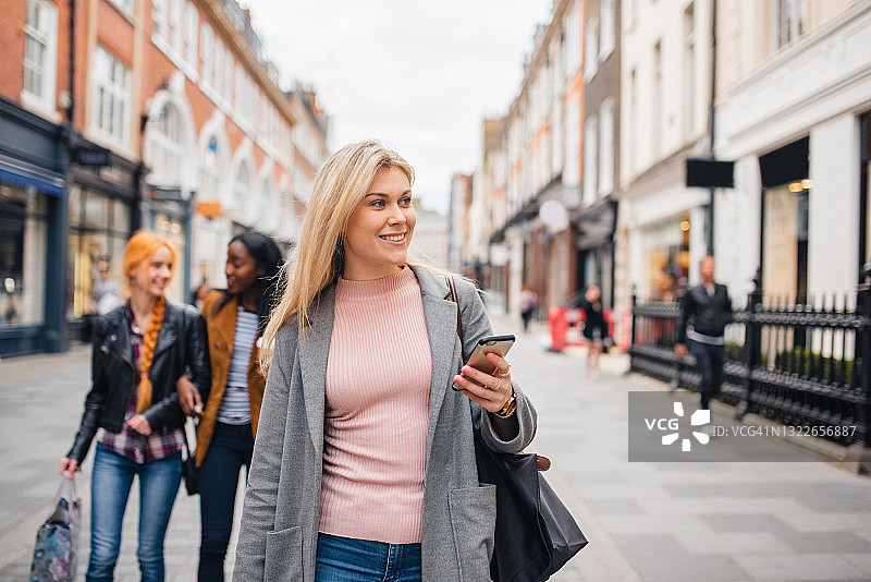 年轻金发女子在伦敦街头使用手机图片素材