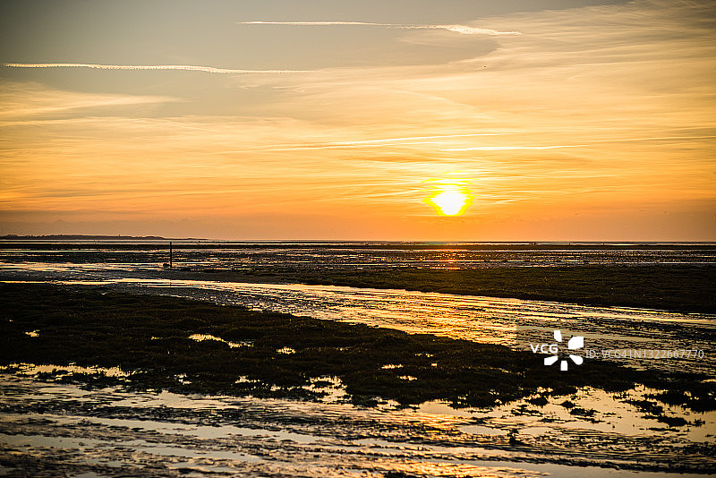 索姆湾河口退潮时（勒克罗图瓦）的日落，展现了植物、沙滩以及云在天空中的倒影图片素材