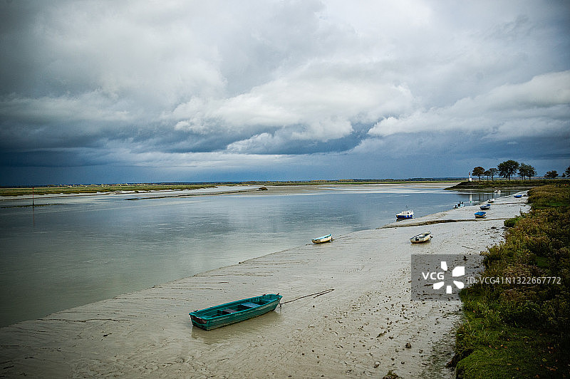 退潮时，索姆湾河口搁浅在沙滩上的船只和小船图片素材
