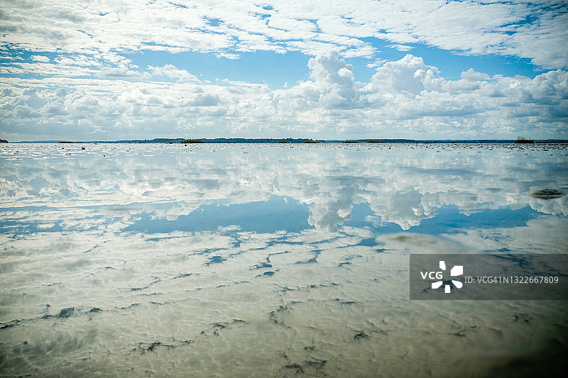 索姆湾河口退潮时显露的植物、沙滩和天空云朵的倒影图片素材