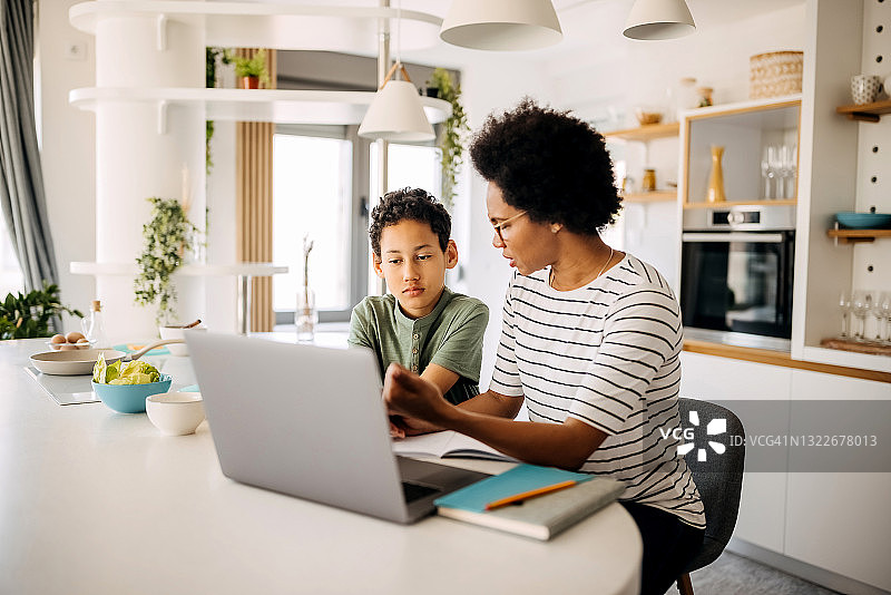 母亲辅导十几岁的儿子做功课图片素材