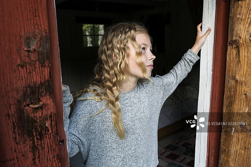 经过木门的金发女孩图片素材